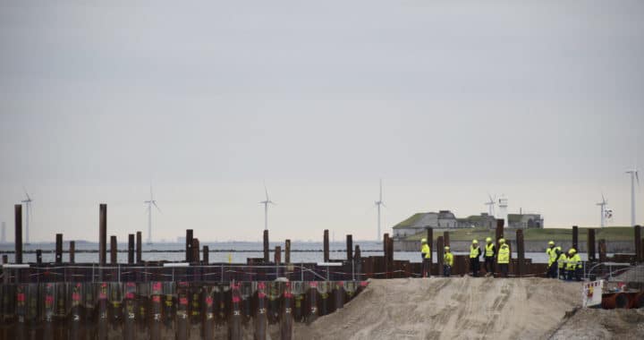 Sikkerhedsklædte mennesker betragter byggegruppen v Kronløbsøens byggeplads.